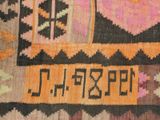 close up of a colorful rug with a black border and a yellow border