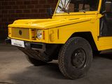a yellow jeep parked in front of a brick wall