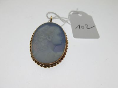 a gold and blue cameo pendant with a woman ' s face