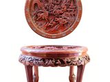 a small wooden table with a carved plate on top of it