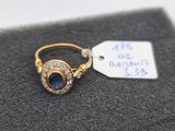 a close up of a gold ring with a sapphire and diamonds