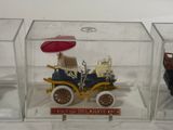 three small toy cars in a glass case