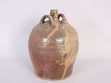 a brown vase that is sitting on a white surface