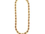 un gros plan d'un collier de perles dorées sur fond blanc