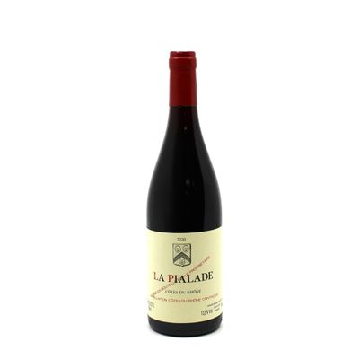 a bottle of red wine sitting on top of a white table