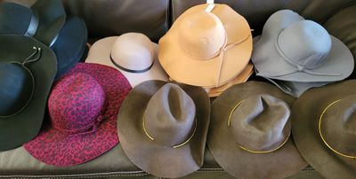 many hats that are sitting on top of a couch