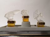 three glass figurines of angels on display in a display case