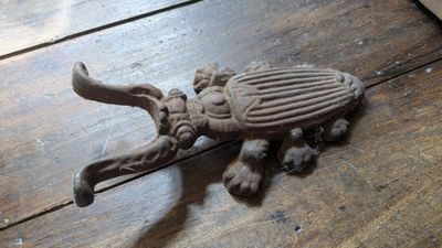 un objet métallique posé sur une table en bois sur laquelle se trouve un oiseau