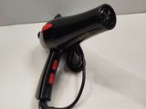 a black blow dryer sitting on a white table