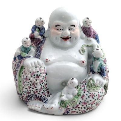 a statue of a laughing buddha sitting on a pillow