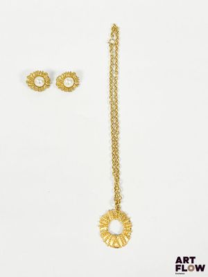 une paire de boucles d'oreilles en or et un collier sur fond blanc