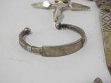 a silver bracelet and a pair of scissors on a table