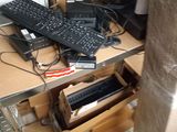 a desk with a keyboard, mouse, and other electronics on it