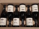 six bouteilles de vin dans un carton sur une table
