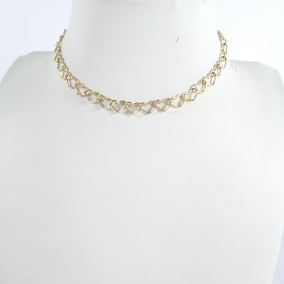 un gros plan sur le torse d'un mannequin portant un collier à chaîne en or