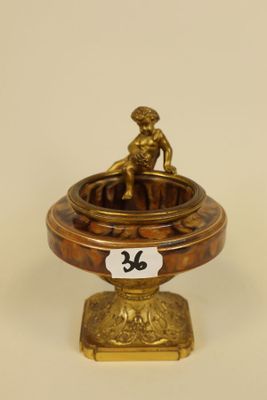 an antique brass plate with a figurine on top of it
