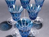 six blue glass goblets sitting on top of each other