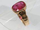 un gros plan d'une bague en or sertie d'une pierre rose