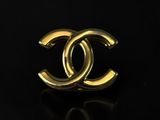 a chanel gold ring on a black surface