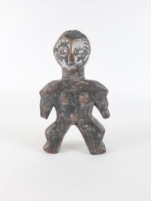 an old figurine of a man standing on a white surface