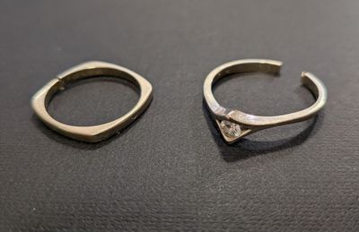 two rings with a diamond on them sitting on a table