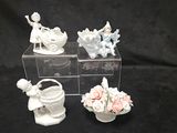 quatre petites figurines blanches exposées sur un fond noir