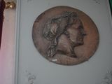 une plaque fixée au mur d'un immeuble sur laquelle figure le portrait d'une femme