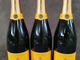 trois bouteilles de champagne sont alignées sur une table