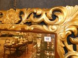 a large mirror with a gold frame in the middle of a room