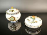 two small white and blue bowls sitting on a black table