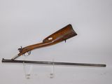 an old rifle on a stand with a wooden handle