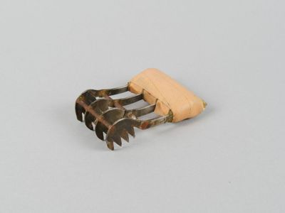 une fourchette avec un manche en bois posée sur une surface blanche