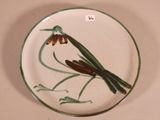 a plate with a bird on it and a flower on the plate