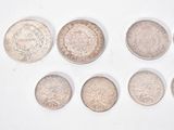 six different types of coins are arranged in a row on a white surface