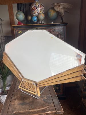 a large mirror sitting on top of a wooden table