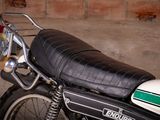 a black and white motorcycle parked in front of a brick wall