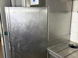 a stainless steel refrigerator next to a sink in a kitchen