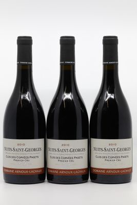 trois bouteilles de vin rouge posées sur une table blanche