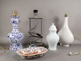 trois vases différents et une lampe posés sur une table