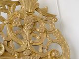 a mirror with a gold frame hanging on the wall