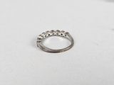 an image of a silver ring sitting on top of a white surface