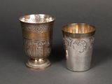 une paire de tasses en argent ornées de motifs, posées sur une table