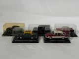 four different model cars in plastic cases sitting on a white surface