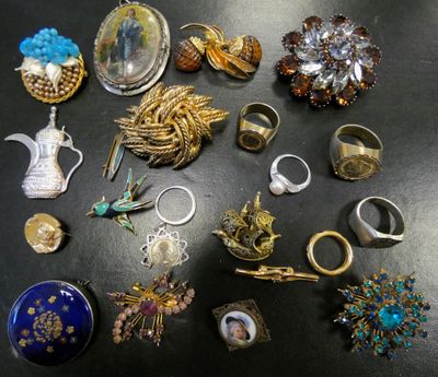 a lot of rings and brooches on a table