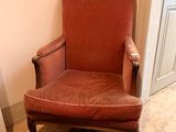 une chaise rouge placée dans une pièce où il y a un tapis au sol