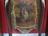 une petite armoire ornée d'un tableau, dans une pièce