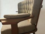 a chair that has a cushion on it in a room