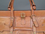 a close up of a brown purse on a table