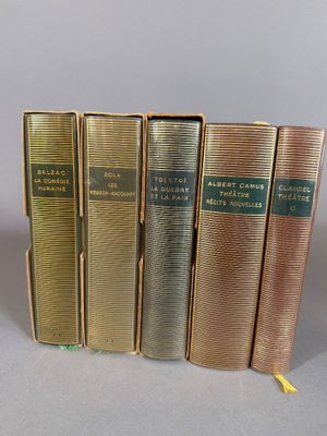 four books are lined up in a row on a gray surface