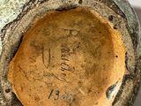 a green vase with writing on it sitting on a table